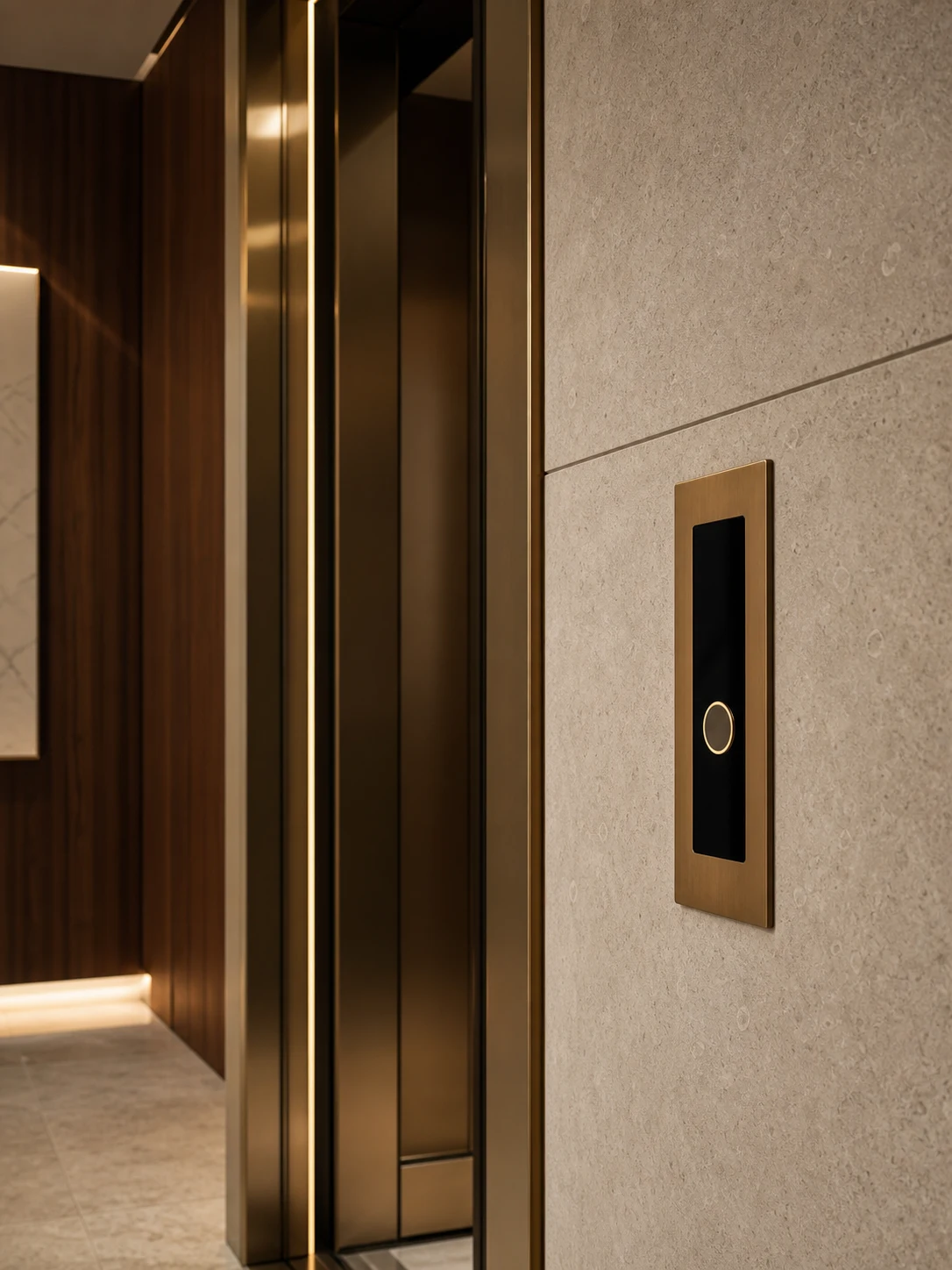 Flush elevator hall panel integrated into a limestone wall beside bronze lift doors